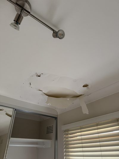 Ceiling with water damage and peeling paint before repair