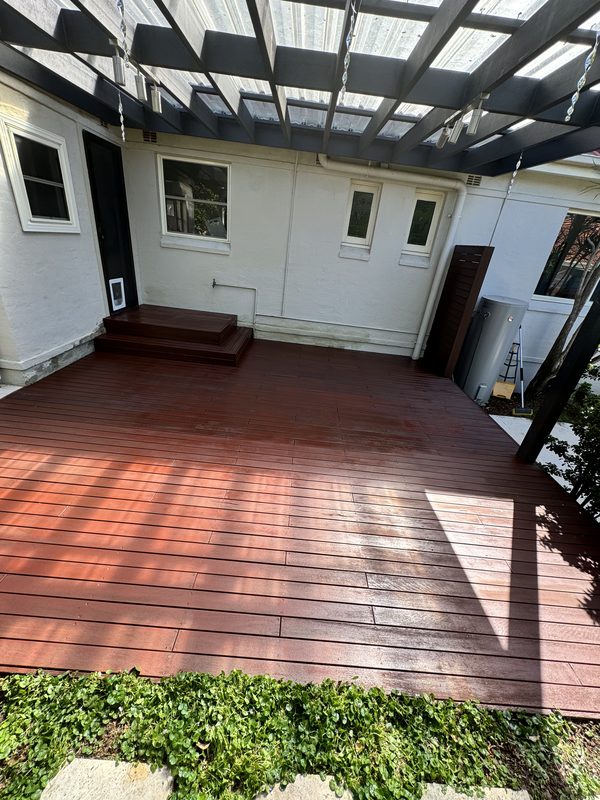 Rear exterior and pergola repainted in white above a timber deck
