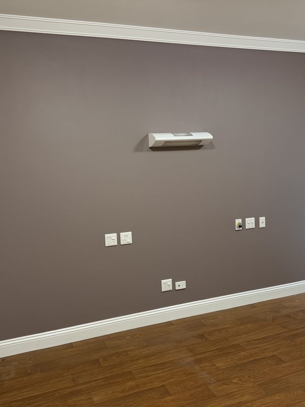 Bedroom feature wall in warm taupe against white cornice and trim